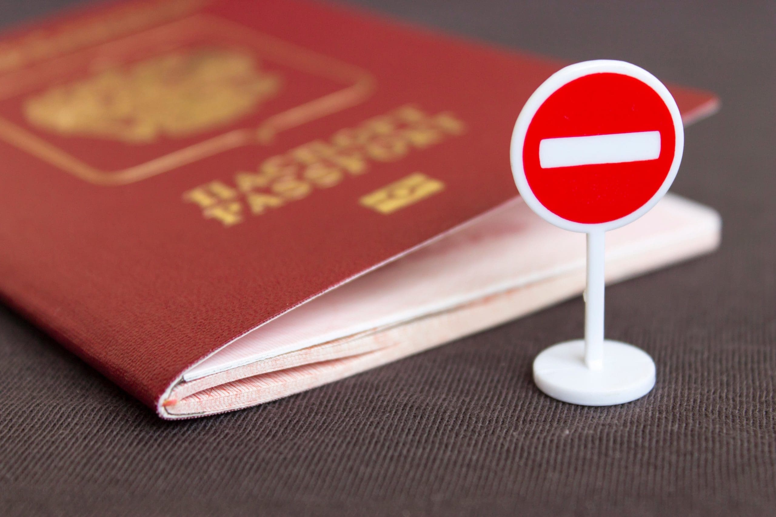 A passport with a red sign next to it.