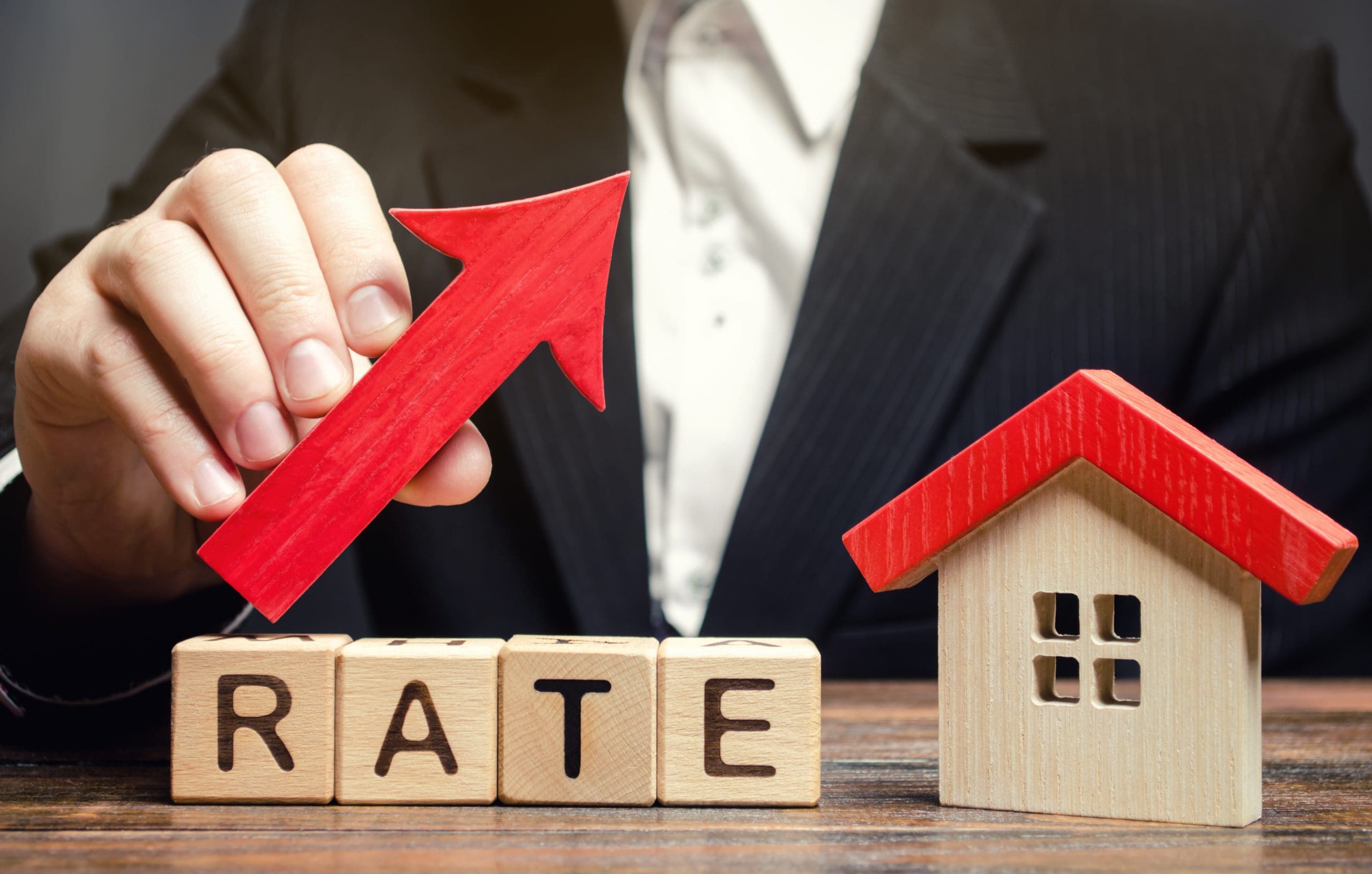 A businessman holding a wooden block with the word rate on it.